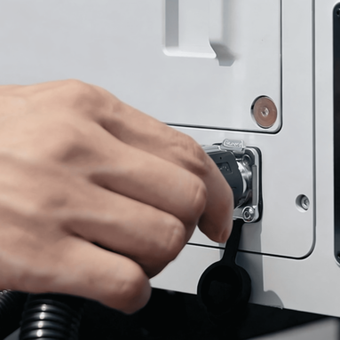 Hand plugging a cable into a device with DJI branding